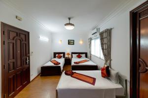 a room with two beds and a door at Hanoi Phoenix Boutique Hotel in Hanoi +11 photos
