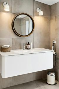 une salle de bains avec un lavabo blanc et un miroir dans l'établissement Indulgence In Architect-Designed House In Vejby, à Vejby Strand