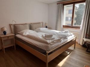 a bedroom with a bed with white sheets and a window at Chesa Chatrigna App 6 - Celerina in Celerina