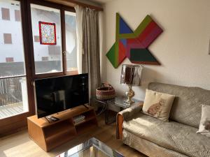 a living room with a couch and a flat screen tv at Chesa Chatrigna App 6 - Celerina in Celerina