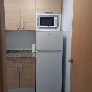 a kitchen with a microwave on top of a refrigerator at Costa d'Or SALOU in Salou