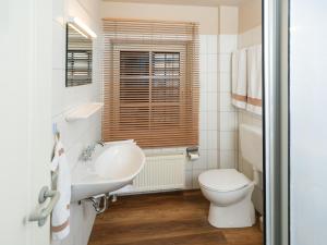 Un baño blanco con inodoro y lavabo. en Spacious Ensemble Hecht Right On The Eider River, en Süderstapel 28 fotos más