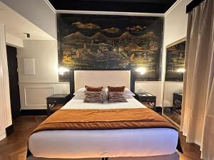 a bedroom with a large bed with two pillows on it at Torre Argentina Relais - Residenze di Charme in Rome +145 photos