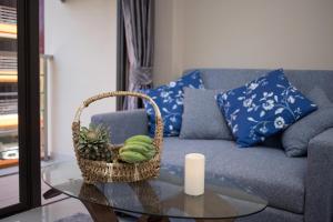 a living room with a couch and a table with a basket at NARA Condo 1BR Pool View NBC Nai Harn in Nai Harn Beach +27 photos