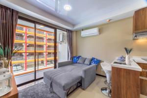 un soggiorno con un divano e una finestra di Chic 1BR Condo Steps from Nai Harn S311 a Nai Harn Beach