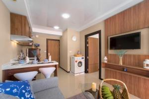 un soggiorno con cucina, TV e soggiorno. di Chic 1BR Condo Steps from Nai Harn S311 a Nai Harn Beach