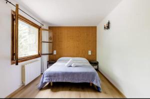 una camera da letto con un letto con una coperta blu e una finestra di Casa Rural Hostel dos Lucas a Biescas