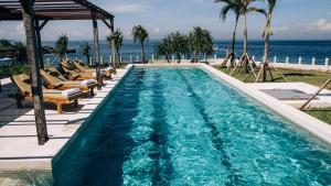 una piscina con sedie a sdraio e l'oceano di Naluna Lembongan a Nusa Lembongan Altre 19 foto