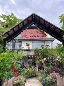 にあるAn Nhiên Homestay- Cánh đồng An Nhấtの「コーヒーとチルで勝つ」と書かれた看板のある建物