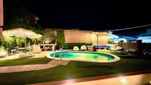 a swimming pool in a yard at night at Maison Belle Époque & suites with pool in Oristano