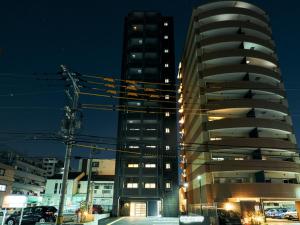 a tall building with a parking lot in front of it at Rakuten STAY Fukuoka-Yakuin - Vacation STAY 28612v in Fukuoka