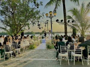 a group of people sitting in chairs at a wedding on the beach at CocoPalm Hoi An River Beach in Hoi An +65 photos