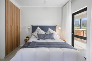 a bedroom with a large white bed with blue pillows at Ballito Hills 824 in Ballito +31 photos