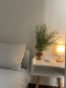 a bed and a table with a lamp and a plant at Mộc miên homestay & coffee dốc lết 