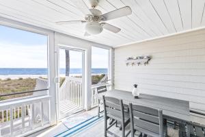 ein Esszimmer mit Tisch und Stühlen und dem Meer in der Unterkunft Beach Club Villa 31 - Luxurious Oceanfront - Beach Walkout in Isle of Palms