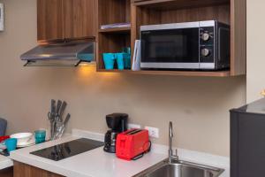 a kitchen with a sink and a microwave at LUMA Condo 1BR Open View NBC Nai Harn in Rawai Beach +22 photos
