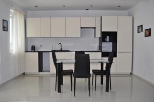 a kitchen with a table and chairs and white cabinets at Apartament Scorpion Modlin in Czosnów