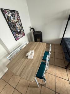 a wooden table with chairs in a room at Appartement dans maison au calme in Forbach
