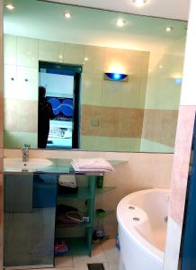 a bathroom with a sink and a tub and a mirror at stan/apartman s pogledom in Sarajevo
