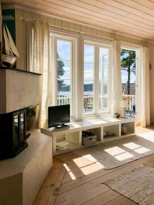 ein Wohnzimmer mit Kamin und Fernseher in der Unterkunft Cabin With Sea View Near Risør in Søndeled