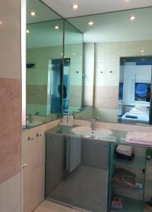 a bathroom with a sink and a large mirror at stan/apartman s pogledom in Sarajevo