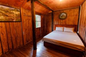 une chambre avec un lit dans une pièce en bois dans l'établissement Cốm Homestay Bản Giốc, à Trùng Khánh 27 autres photos