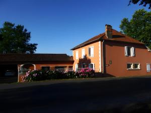 an orange house with flowers on the side of a street at Gite Lou Haou in Nassiet