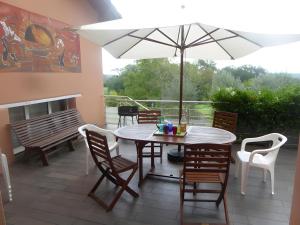 a patio with a table and chairs and an umbrella at Gite Lou Haou in Nassiet