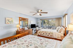 a bedroom with two beds and a television at Lagoon Villa 25 - Heart of Wild Dunes, Quick Walk to Beach in Isle of Palms