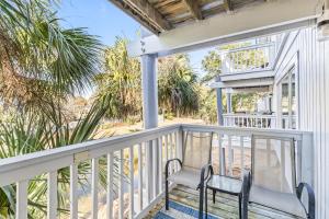a porch with a bench and palm trees at Lagoon Villa 25 - Heart of Wild Dunes, Quick Walk to Beach in Isle of Palms