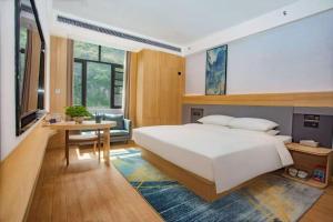 een slaapkamer met een groot wit bed en een tafel bij Imperial Dragon Bay Mandala Hotel in Pingxiang +33 foto's