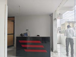 a man standing in a room looking out of a window at HOTEL O CROWD in Durg