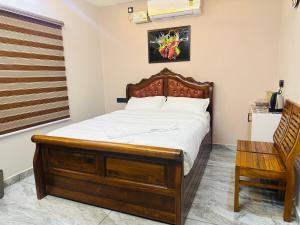 a bedroom with a wooden bed and a chair at North paradise in Cochin +4 photos