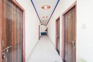 a corridor in an office with wooden doors at SPOT ON M L Paying Guest House in Rāmnagar