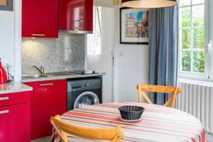 a kitchen with a table and a sink and red cabinets at Entre Terre et Mer in Ciboure