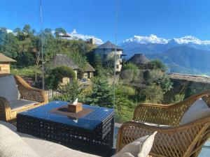 a patio with a table and chairs and a view of mountains at The hills in Pokhara