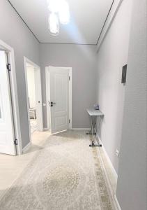 an empty room with a white door and a rug at Квартира в новом доме недалеко от центра Бишкека in Bishkek