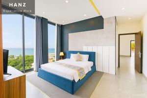 a bedroom with a blue bed and large windows at S79 Happy 88 Tran Hung Dao Street in Phu Quoc