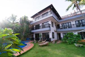 a large white house with a yard with a bench at Venus Mũi Né Resort in Mui Ne