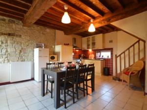 a kitchen with a black table and chairs and a refrigerator at Holiday Home in Saint-Clément near the Sea in Osmanville