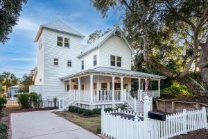 ein weißes Haus mit einem weißen Zaun in der Unterkunft Seaside Cottage 81 - Pristine Grand Pavilion Home Pool Pass in Isle of Palms