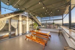 ダラットにあるHappy Home Da Latの木製のベンチと大きな窓のある建物