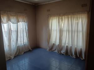 a room with white curtains and a blue tile floor at Sasavona Haven in Vosburg