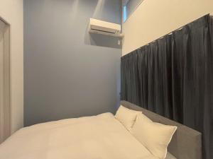 1 dormitorio con 1 cama y aire acondicionado en Hotel Star Residence 3 WEST, en Fukuoka