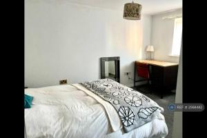 a bedroom with a bed with a dresser and a desk at South Wales Coastal Retreat in Llanelli