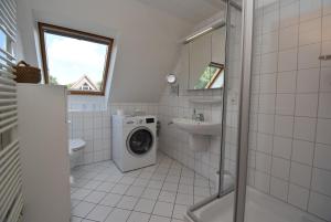 a bathroom with a washing machine and a sink at Inselrose in Langeoog +22 photos