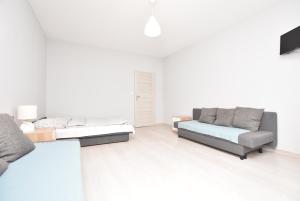 a white living room with a couch and a bed at ApartHostel "Przy Rynku" Wrocław in Wrocław +7 photos