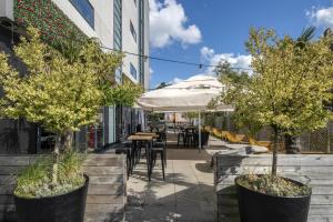 a patio with trees and tables and an umbrella at Best Western Amsterdam in Amsterdam