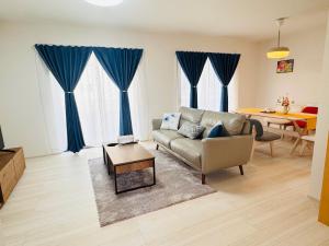 a living room with a couch and a table at 大阪りんくん新築Yutori蘭 in Izumi-Sano