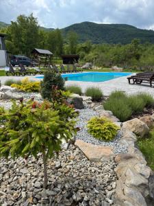 a rock garden with a pool and a pine tree at Bier House in Velyatyn